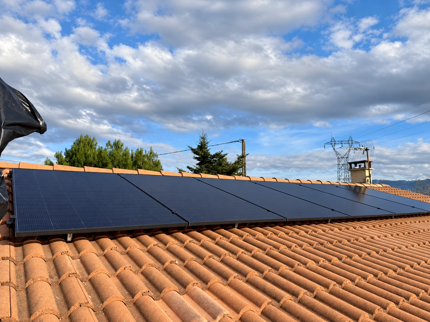 Panneaux photovoltaïques sur une toiture en tuiles entourée d’arbres — VSD Énergie