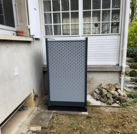 Groupe extérieur de pompe à chaleur posé près d’une véranda