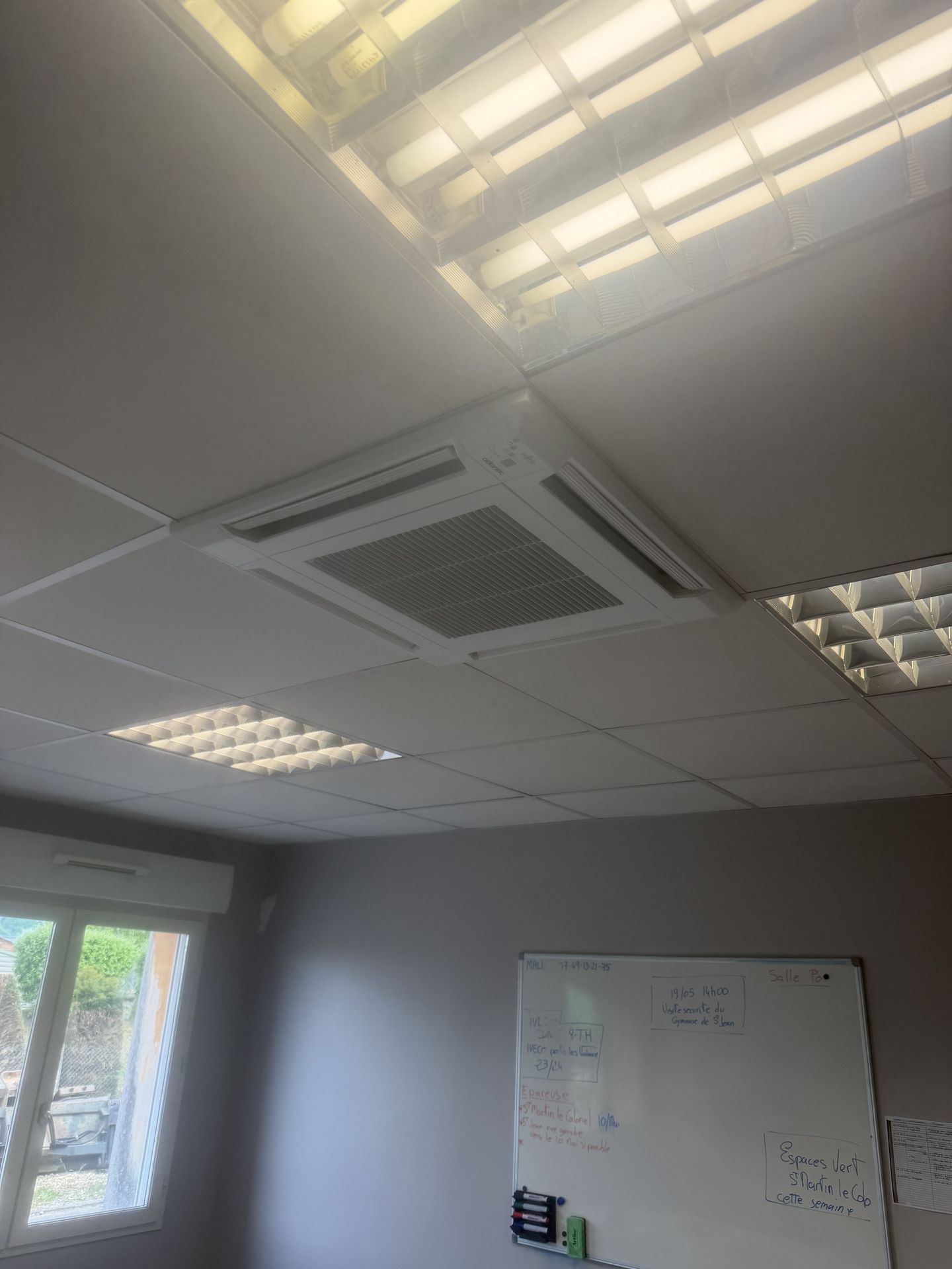 Cassette de climatisation encastrée dans un faux plafond.